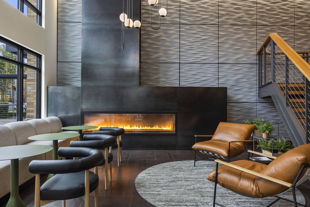 a lobby with leather chairs and a fireplace