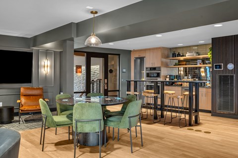 Community dining space with modern kitchen and bar seating at The Lyric Apartments, Washington