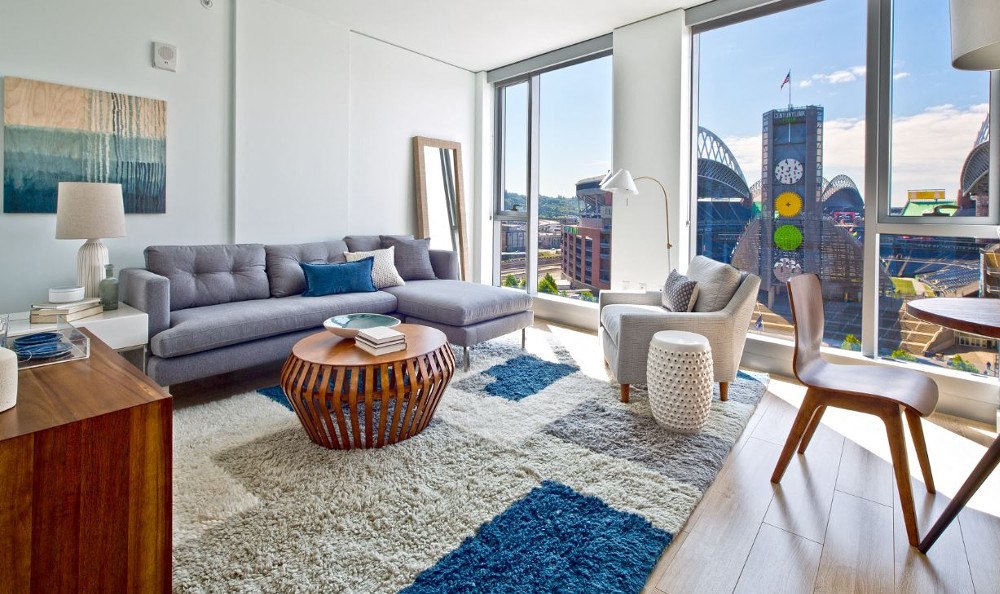 a living room with a couch and chairs and a rug