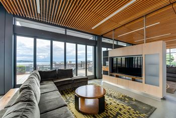 A modern living room with a large window overlooking the water.