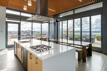 A modern kitchen with a large island and a view of the city.