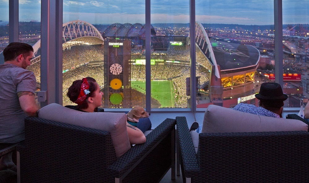 a woman sitting on a chair looking out the window of a skyscraper