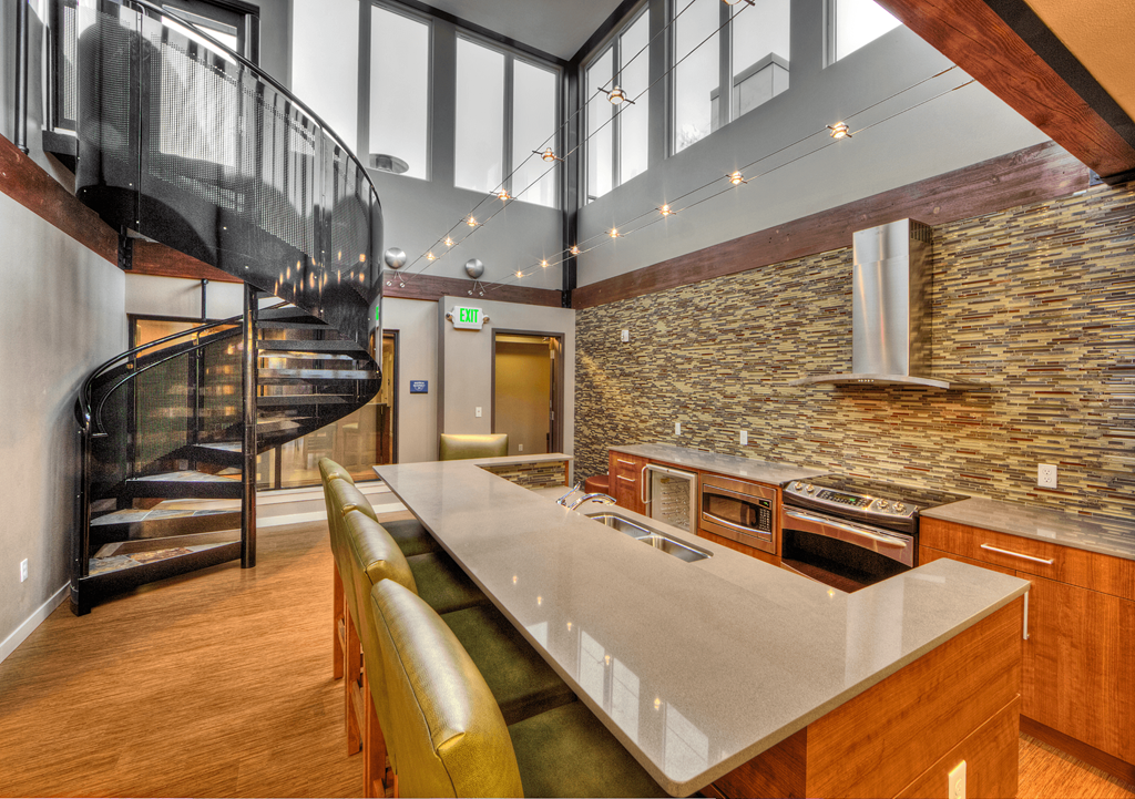 Resident lounge with full kitchen and staircase to rooftop deck