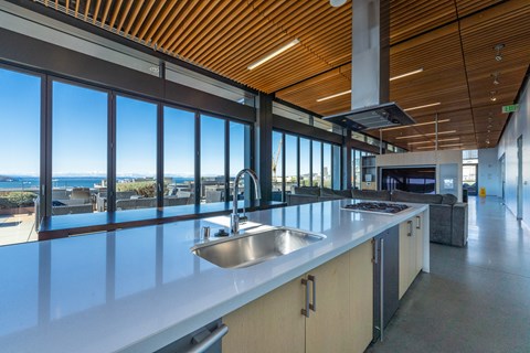 a large kitchen with a sink and a view of the ocean