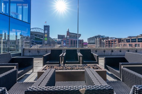 views of the city skyline from the roof of a building with lounge chairs