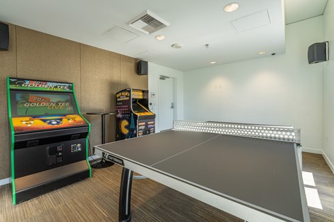 a game room with a ping pong table and a video game