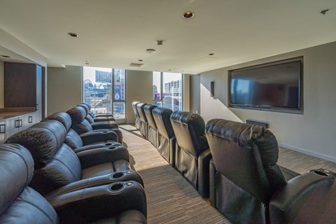 a large screening room with leather chairs and a television