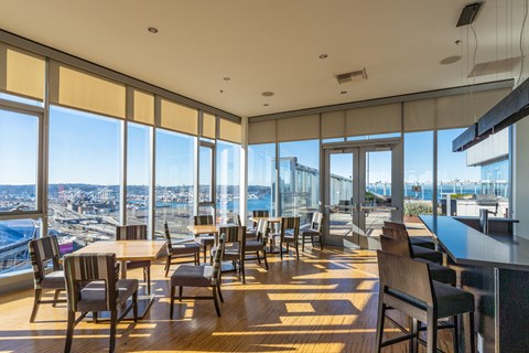 a restaurant with tables and chairs and a view of the city