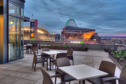 a terrace with tables and chairs and a view of a stadium