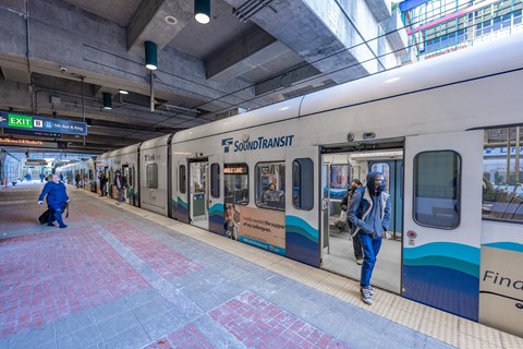 a subway train at a station with doors open and passengers exiting