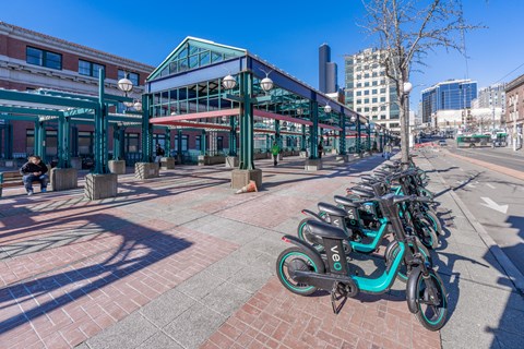 a row of bikes parked on a sidewalk in front of a building
