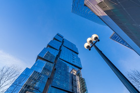 a street light in front of tall glass skyscrapers