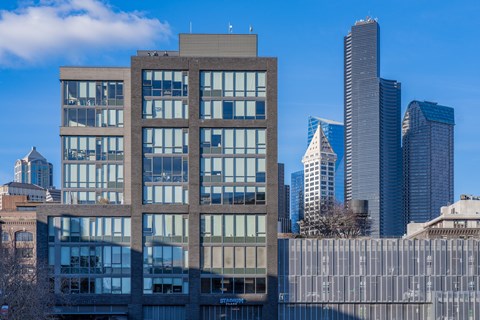 a large brick building with skyscrapers in the background