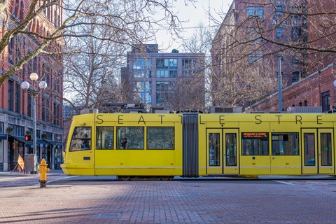 a yellow streetcar on the street in the city