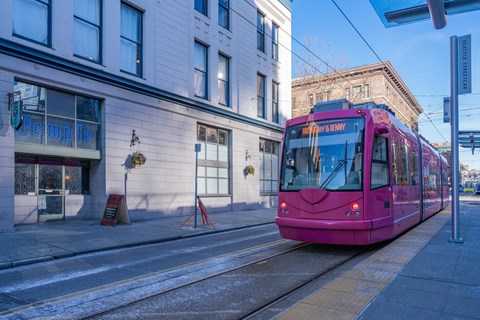 a pink streetcar on a city street