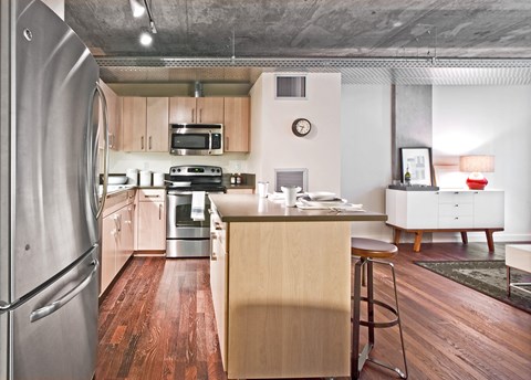 a kitchen with a island and a stainless steel refrigerator