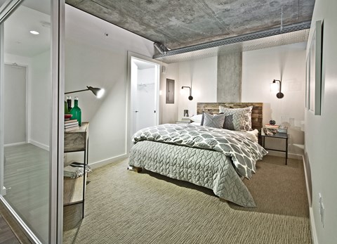 a bedroom with a bed and a concrete ceiling