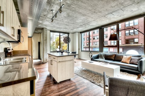a living room with a kitchen and a large window
