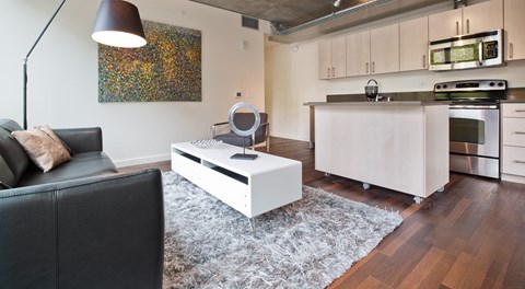 a living room with a couch and a coffee table in front of a kitchen
