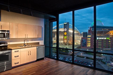 a kitchen with a view of a stadium and a city at night