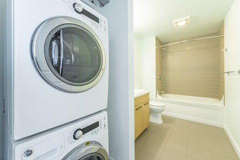 a washer and dryer in a laundry room next to a bathroom