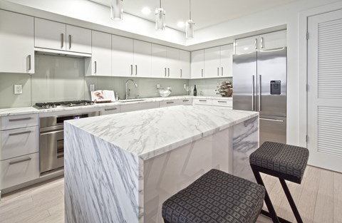 a large kitchen with a marble counter top and stainless steel appliances
