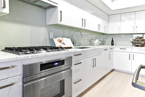 a white kitchen with stainless steel appliances and white cabinets