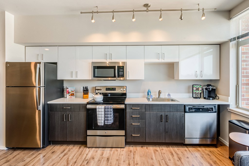 a modern kitchen with stainless steel appliances and white cabinets
