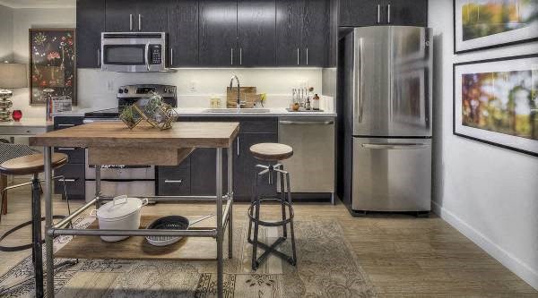 a kitchen with stainless steel appliances and a wooden table