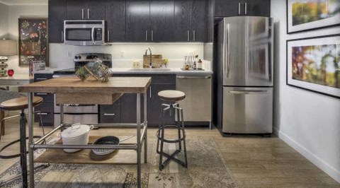 A kitchen with a wooden table and a refrigerator.