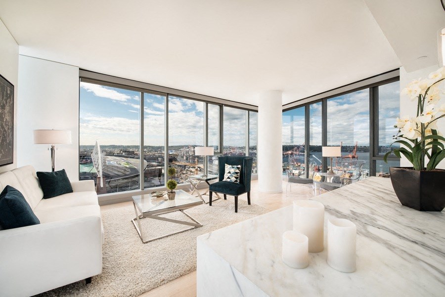 a living room with a view of the city and a couch and a table