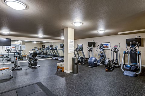 Fitness center with cardio machines and free weights at The Corydon Apartments, Washington