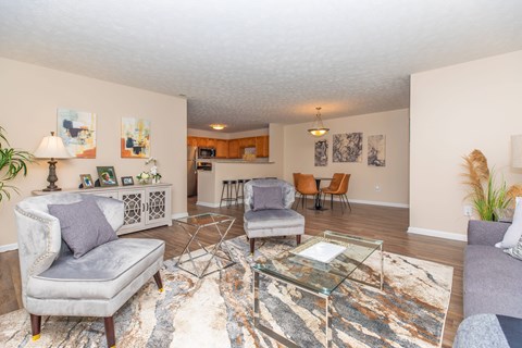 A living room with a grey couch and a glass coffee table.
