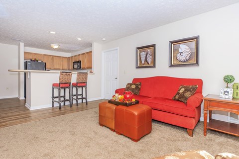 A living room with a red couch and a wooden coffee table.