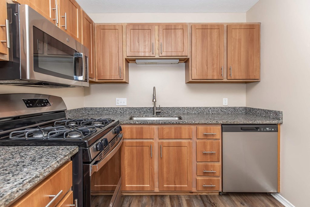 a kitchen with granite counter tops and wooden cabinets