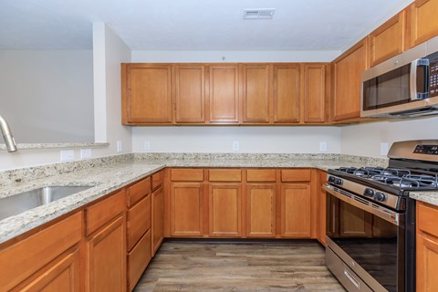A kitchen with wooden cabinets and a granite countertop.