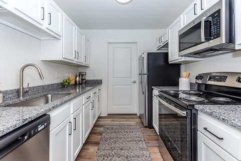 a kitchen with white cabinets and black appliances