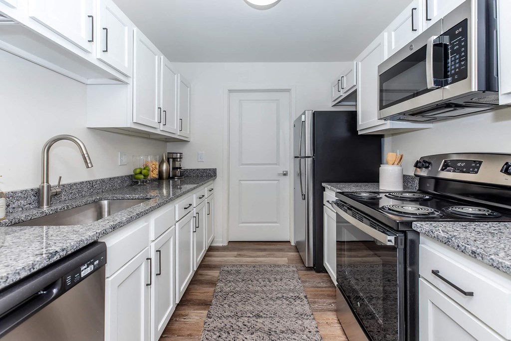 a kitchen with white cabinets and black appliances
