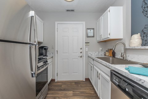 a kitchen with stainless steel appliances and a white door