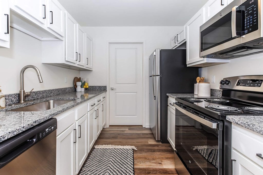 a kitchen with stainless steel appliances and white cabinets
