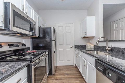 a kitchen with granite counter tops and a stove and a refrigerator