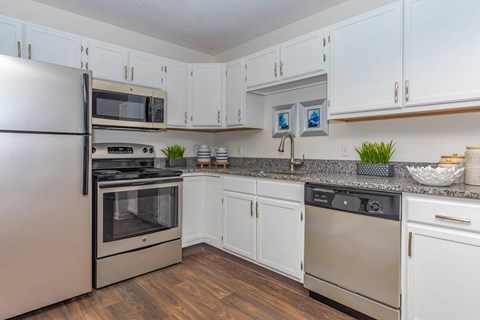 a kitchen with stainless steel appliances and white cabinets