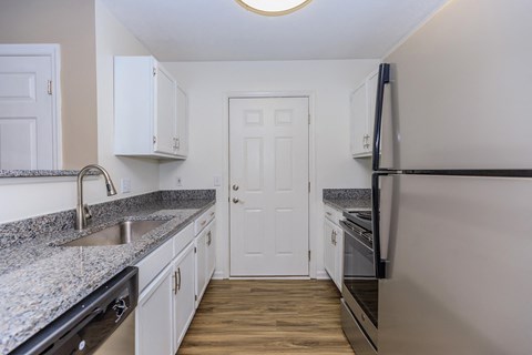a kitchen with granite counter tops and stainless steel appliances