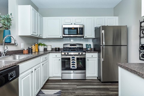 a kitchen with stainless steel appliances and white cabinets