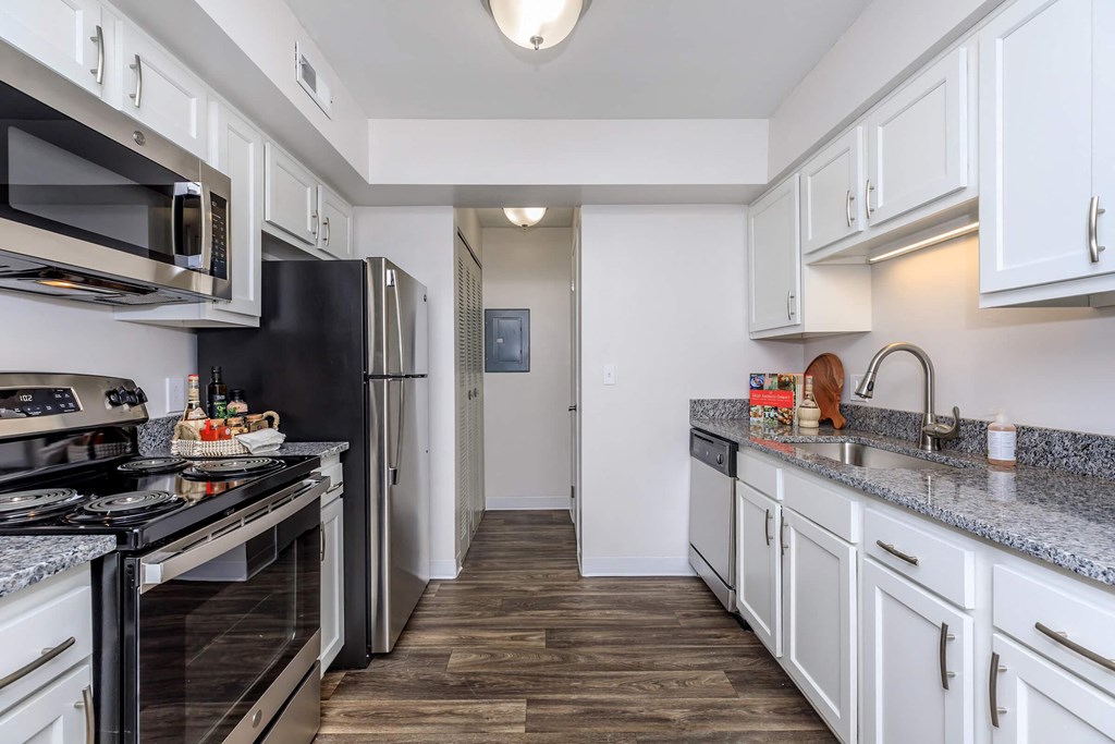 A kitchen with black appliances and white cabinets.