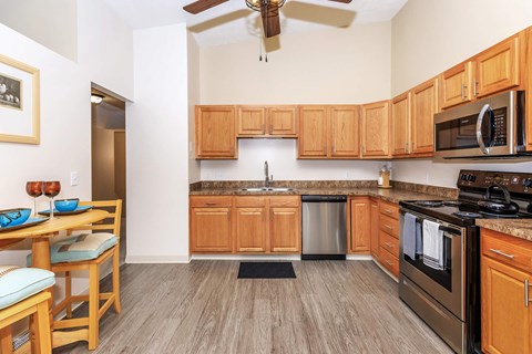 A kitchen with wooden cabinets and a stainless steel oven.
