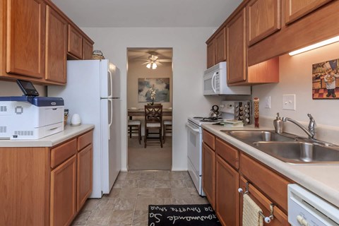 a kitchen with wooden cabinets and a sink and a refrigerator