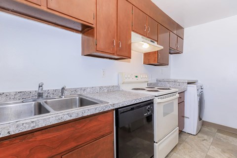 a kitchen with wood cabinets and white appliances and a sink