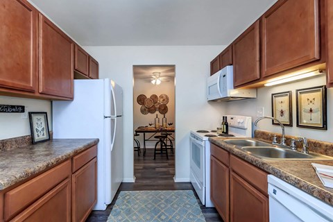 a kitchen with white appliances and wooden cabinets