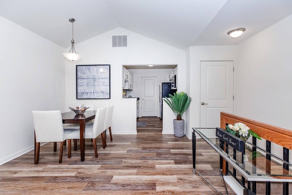 a dining room with a table and chairs and a hallway to a kitchen